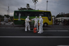 Disinfectant staff from the Yogyakarta administration prepare their sprayers before evacuating a man suspected of dying from COVID-19, at the zero kilometer area on March 30. JP/Arnold Simanjuntak
