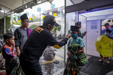 Worshippers walk through the disinfectant chamber and have their temperatures checked before Friday prayers at Jogokariyah Mosque in Yogyakarta on April 3. Some people keep going to mosques, although the government has called on people to pray at home. JP/Arnold Simanjuntak
