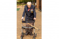 Retired British Army Captain Tom Moore, 99, walks to raise money for health workers, by attempting to walk the length of his garden one hundred times before his 100th birthday later this month, in Britain in this undated handout taken sometime April 2020.  