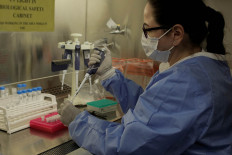 Microbiologist Milagros Sola processes COVID-19 tests in a lab at the Madigan Army Medical Center at Joint Base Lewis-McChord in Washington, United States, on April 14.  