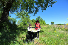 Giulio Giovanni, 12, with his mother Gloria, holds a tablet after traveling from his family cottage in the Tuscan countryside, where he has no internet signal, to the top of a hill where he is able to access the Internet to participate in online lessons while schools remain closed due to the spread of coronavirus disease (COVID-19), in Scansano, Italy, April 15, 2020. 