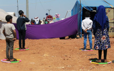 Displaced children attend a puppet show during an event organized by Violet Organization, in an effort to spread awareness and encourage safety amid coronavirus disease (COVID-19) fears, at a camp in the town of Maarat Masrin in northern Idlib, Syria, on April 14, 2020. 