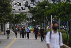 Workers head home after a day's work on Jl Jenderal Sudirman in Jakarta on April 16, 2020.