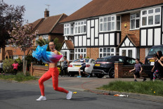 Elyse Blemmings, also known as the Mancunian Motivator leads residents of Chigwell Park Drive in a fitness class outside their homes in Chigwell, Britain, on April 16, 2020. 
