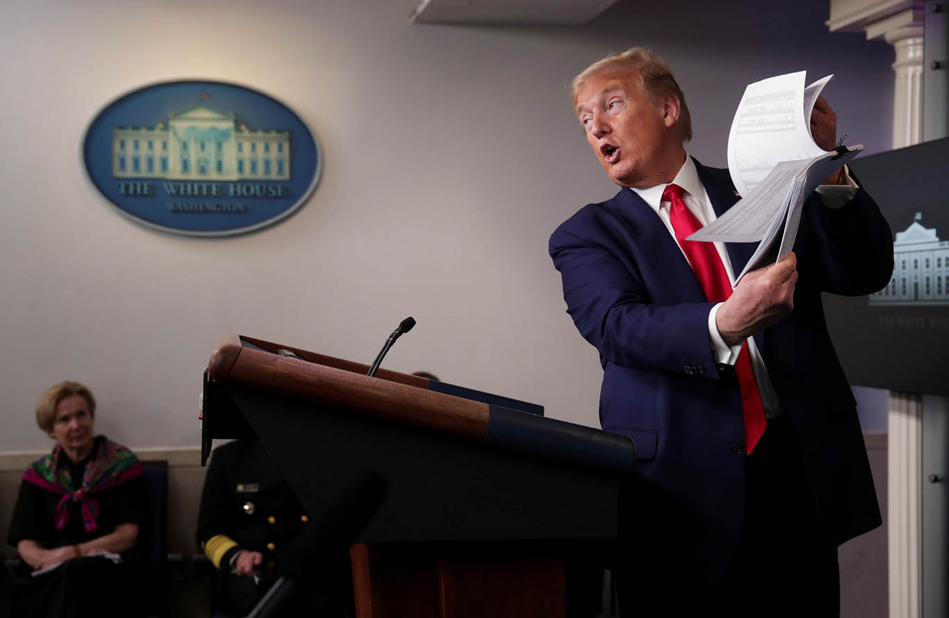 US President Donald Trump holds up a list of coronavirus testing locations that he says US states can use as he addresses the daily coronavirus task force briefing while White House coronavirus coordinator Dr. Deborah Birx looks on at the White House in Washington, US., April 20, 2020.