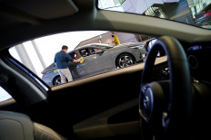 An employee wearing a mask to prevent contracting the coronavirus disease (COVID-19) wipes the exterior of a Hyundai Motor's vehicle at Hyundai Motor Studio in Goyang, South Korea, April 21, 2020. 