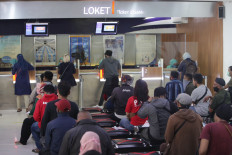 People wait in line to obtain refunds for train tickets at Senen railway station in Central Jakarta on Thursday. State-owned railway operator PT Kereta Api Indonesia (KAI) has suspended services for local and long distance routes following the Idul Fitri exodus ban imposed on April 24.   