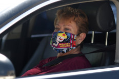 A woman wears a Wonder Woman mask as she waits in line at a Los Angeles Food Bank drive-through food giveaway as the global outbreak of coronavirus disease (COVID-19) continues, in Los Angeles, California, United States, on April 21, 2020. 
