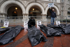Demonstrators protest among fake body bags outside the Trump International Hotel during a demonstration critical of the Trump adminstration's handling of the coronavirus outbreak in Washington, U.S., April 23, 2020. 