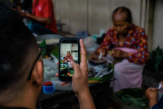 A customer takes a photo of Satinem with his smartphone. JP/Anggertimur Lanang Tinarbuko