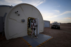This picture taken on April 17, 2019 shows a woman wearing a spacesuit walking out of 'Mars Base 1', a C-Space Project, in the Gobi desert, some 40 kilometres from Jinchang in China's northwest Gansu province. 