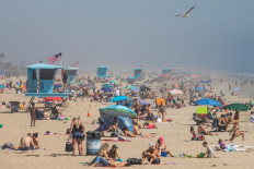 People enjoy the beach amid the novel coronavirus pandemic in Huntington Beach, California on April 25, 2020. 