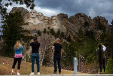 Tourists take photos of Mount Rushmore National Memorial on April 23, 2020 in Keystone, South Dakota. 