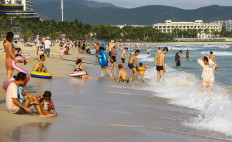 This photo taken on April 20, 2020 shows people enjoying the beach in Sanya in China's southern Hainan province.
