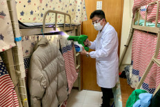 A man demonstrates how to spray MAP-1, an antimicrobial coating that a team of university researchers claimed to be effective in killing virus, bacteria and spore, at a bedspace apartment in Hong Kong, China April 21, 2020. 