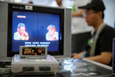 This photo taken on August 12, 2017 shows a Nintendo Super Famicom, a 1990s era 16-bit console that was marketed outside Japan as the Super NES (Nintendo Entertainment System), running the hit Capcom beat 'em up game Street Fighter II on a cathode ray tube television, at a retro gaming expo in Hong Kong. 
