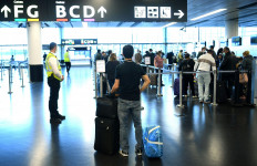 Flight passengers queue at a check in desk of the low-cost airline Wizz Air on May 1, 2020 at the Schwechat airport near Vienna, Austria. 