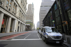 NYPD vehicles sit parked on a nearly empty Broadway outside of the Fulton Center subway station during the coronavirus pandemic on April 25, 2020 in New York City. 