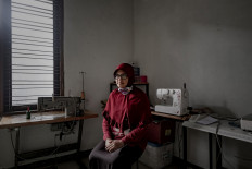 Dwi Rahayu Februarti sits in her mask workshop at her home in Sleman, Yogyakarta. JP/Arnold Simanjuntak
