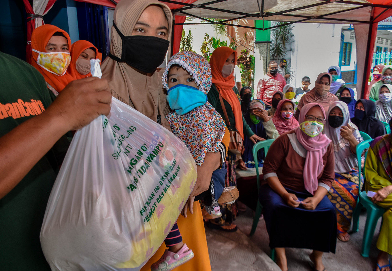 Women queue to receive staple food packages in Sukoharjo, Malang, East Java, on May 3. The government has spent Rp 183.5 trillion (US$12.6 billion), 26.4 percent, of the total budget for its COVID-19 response, mostly to fund social assistance programs.