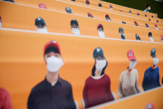 Baseball - KBO Regular season - SK Wyverns v Hanwha Eagles - Munhak Baseball Stadium, Incheon, South Korea - May 5, 2020   A man wearing a face mask is seen behind the dummies replacing the audience before the match, despite most sports being cancelled around the world the local league starts behind closed doors due to the spread of the coronavirus disease (COVID-19)   