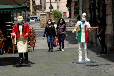 Protective face masks are seen on statues of a waiter and a chef outside bars and restaurants that have reopened for takeaway services, as Italy begins a staged end to a nationwide lockdown due to the spread of the coronavirus disease (COVID-19), in Rome, Italy May 5, 2020. 