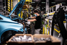 An employee wearing a protective mask against the spread of the novel coronavirus, COVID-19, works along the assembly line that produces both the electric vehicle Renault Zoe and the hybrid vehicle Nissan Micra, at Flins-sur-Seine, the largest Renault production site in France on May 6, 2020. - To reopen following the March 17th lockdown across France, the factory has had to enforce all the safety measure required to reduce any spread of COVID-19 at the assembly plant, with workers having to wear protective masks and gloves and diving the assembly line into individual parts to spot any person-to-person contamination. 