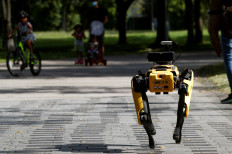 A four-legged robot dog called SPOT patrols a park as it undergoes testing to be deployed as a safe distancing ambassador, following the coronavirus disease (COVID-19) outbreak, in Singapore May 8, 2020. 