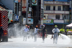 Firefighters spray disinfectant to sanitize a road as a preventive measure against the COVID-19 coronavirus a day before the government-imposed nationwide lockdown being eased, in Colombo on May 10, 2020. 