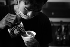 Kadek swirls froth milk into a cup of coffee in a café in Gianyar, Bali. JP/M Azis Dicky