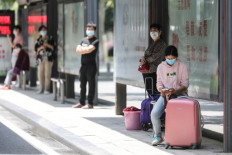 People wait at a bus station in Wuhan in China's central Hubei province on May 11, 2020. China reported a second day of new cases of coronavirus in Wuhan on May 11 after a month without new infections at the pandemic's global epicentre, offering a stark warning of the dangers of a fresh wave. 