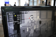 A screen shows a thermographic image of people walking through a temperature screening point at the Hong Kong International Airport, following the COVID-19 outbreak, in Hong Kong, China May 7, 2020.
