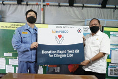 Timely help: The president director of PT Krakatau POSCO, Kim Jhi-yong (left), presents a POSCO donation that resembles Korean-made COVID-19 rapid test kits to Cilegon Mayor Edi Ariadi in Cilegon on May 13.