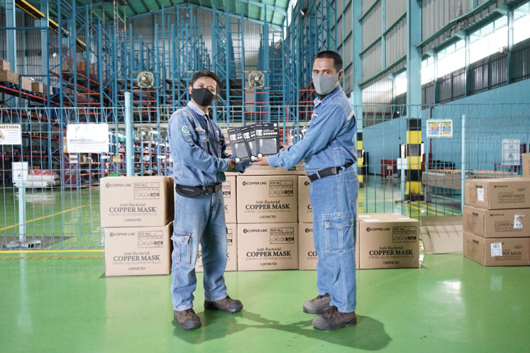 For protection: PT Krakatau POSCO president director Kim Jhi-yong (left) presents face masks to an employee of Krakatau POSCO’s business partner company in Cilegon, Banten, on May 5.
