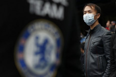 In this file photo taken on March 8, 2020, a Chelsea supporter wearing PPE (personal protective equipment), including a face mask as a precautionary measure against COVID-19, awaits kick off in the English Premier League football match between Chelsea and Everton at Stamford Bridge in London. 