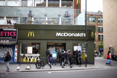 Delivery men are seen outside a reopened McDonald's with take-out only deliveries in Dalston, following the outbreak of the coronavirus disease (COVID-19), London, Britain, on May 13, 2020. 