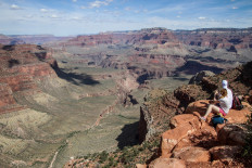 Hikers walk by the edge of the cliffs of the Grand Canyon on May 15, 2019.