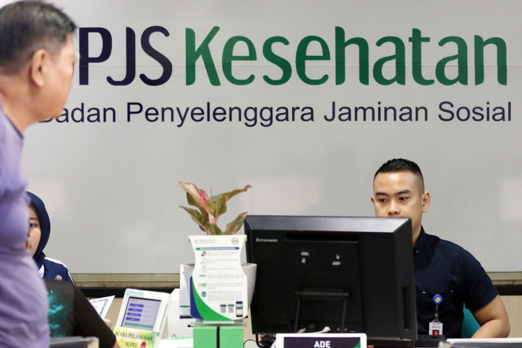 An employee serves a customer on Nov. 6, 2019 at the Matraman office of the Healthcare and Social Security Agency (BPJS Kesehatan) in South Jakarta.