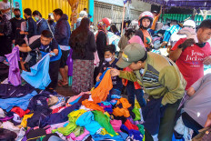 Shoppers choose from a pile of secondhand clothes being sold for Rp 20,000 (US$1.35) a piece in Malang, East Java, on Sunday. The number of patients under supervision for COVID-19 increases at an average rate of seven people per day in Malang. JP /Aman Rochman