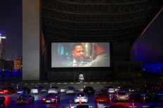 People sit in their cars watching a movie in a drive-in cinema at the Mall of the Emirates, following the outbreak of the coronavirus disease (COVID-19), in Dubai, United Arab Emirates, on May 13, 2020.