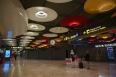 Passengers walk at the terminal 4 of the Madrid-Barajas Adolfo Suarez airport in Barajas on May 16, 2020. 