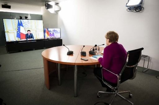 This Handout photo made available by the German government's press office shows German Chancellor Angela Merkel speaking with French President Emmanuel Macron, via video link, at the Chancellery in Berlin, Germany, on May 18, 2020 on the effects of the novel coronavirus COVID-19 pandemic.