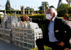 Mini-Europe Director Thierry Meeus wearing a protective mask talks to children during the reopening of 'mini-Europe' theme park where people can wonder across small scale models of European capitals landmarks as Belgium began easing lockdown restrictions amid the coronavirus disease (COVID-19) outbreak, in Brussels, Belgium, on May 18, 2020. 