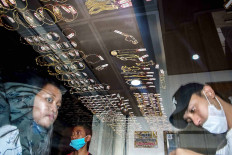 Two consumers (left) complete their transactions at a gold shop in Singosari Market in Malang, East Java, on May 19. The store recorded a surge of gold jewelry sales ahead of Idul Fitri, rising from 10 to 25 transactions per day. JP/Aman Rochman

