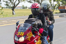 A way back home: Two people ride on a motorcycle to return to their hometown on the Pantura Jatisari route in Karawang, West Java, on Wednesday. Antara/Nova Wahyudi
