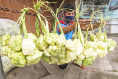 Business as usual: A ketupat package vendor puts his products on display in Depok, West Java, on Thursday. The ketupat is a popular dish during Idul Fitri in Indonesia. Antara/Asprilla Dwi Adha
