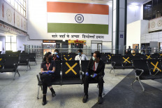 AirAsia staff members (front) speak as they maintain social distancing at the Sardar Vallabhbhai Patel International Airport after the government eased restrictions imposed as a preventive measure against the COVID-19 coronavirus, in Ahmedabad on May 24, 2020. 