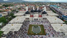 Business as usual: An aerial photograph shows people attending Idul Fitri prayers, marking the end of Ramadan at Baiturrahman Mosque in Banda Aceh, Aceh province, on Sunday. AFP/Adi Gondronk