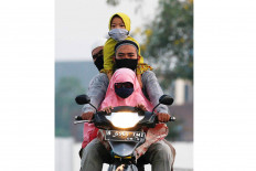 Family bonding: Two men and a young girl ride a motorcycle to attend Idul Fitri prayers amid the COVID-19 outbreak in Bekasi, West Java, on Sunday. Reuters/Willy Kurniawan