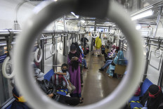 On the move: Passengers board the Electric Train (KRL) at Manggarai Station, Jakarta, on May 25, 2020.
